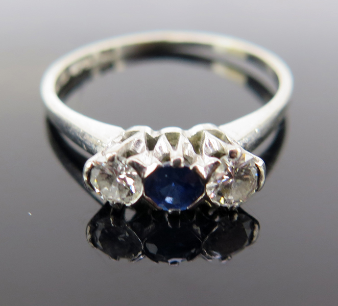 Ring, 18 karat vitguld med 2 briljantslipade diamanter om totalt cirka 0,2 carat samt 1 facettslipad safir, stämplad CG Hallberg Stockholm, innerdiameter 17 mm, vikt 2,4 gram_26744a_lg.jpeg